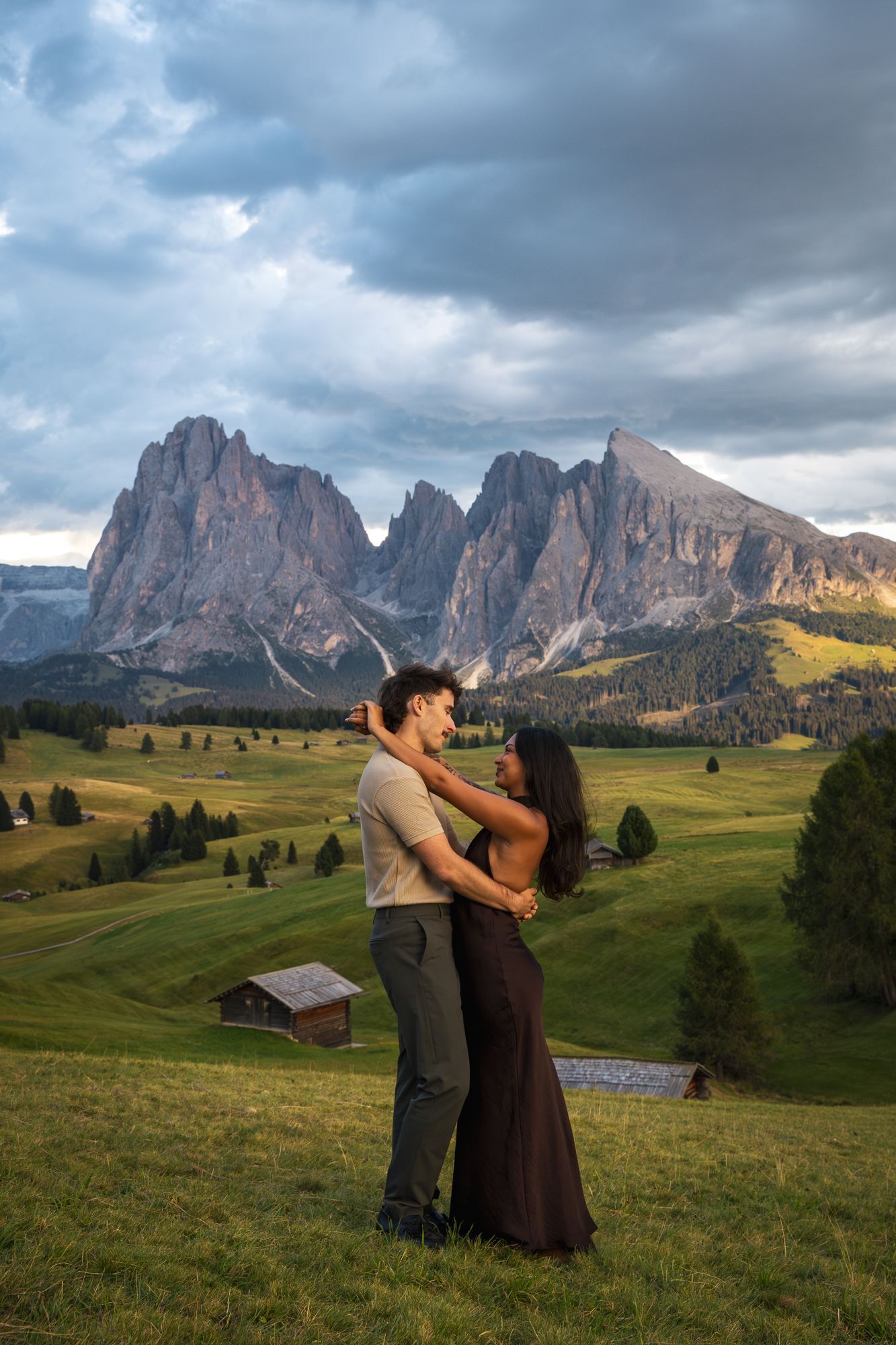 Un couple enlacé dans les alpages, face aux sommets des Dolomites