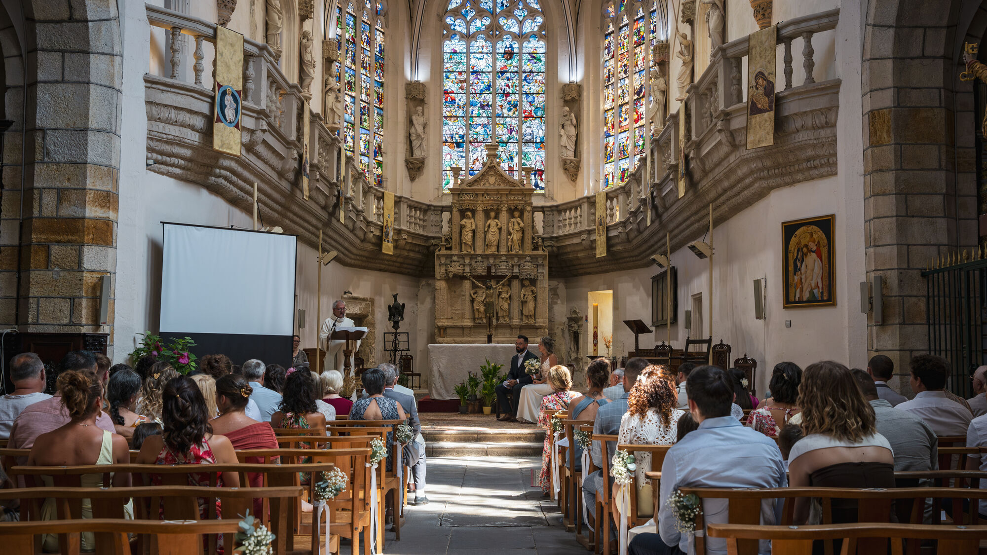 L'église pleine, les vitraux au fond de la nef