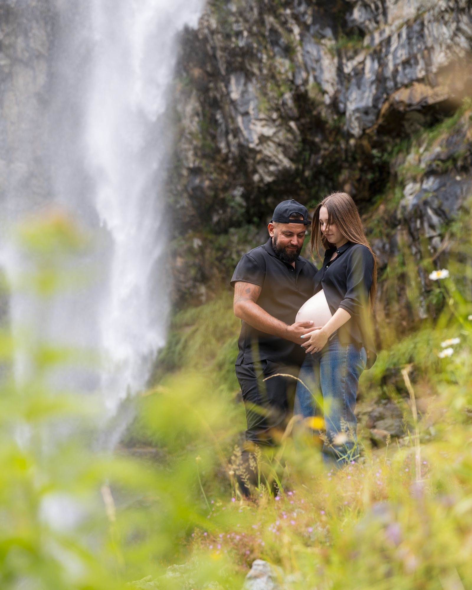 Le couple dans les herbes, la cascade derrière eux